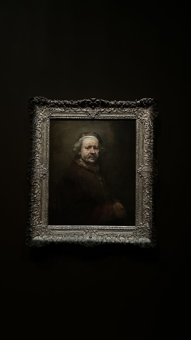 A portrait painting lit in a dark gallery
